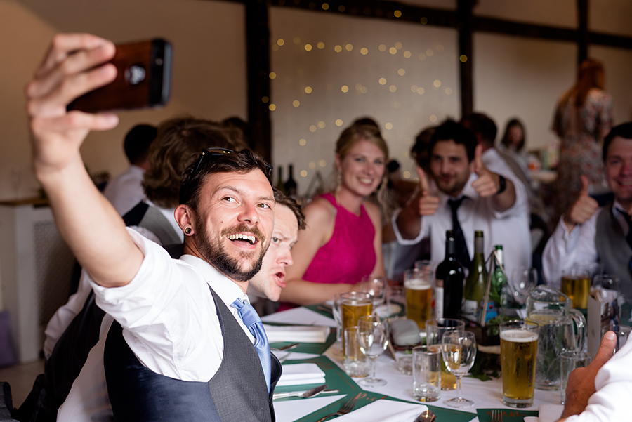 wedding guests at the table taking a selfie