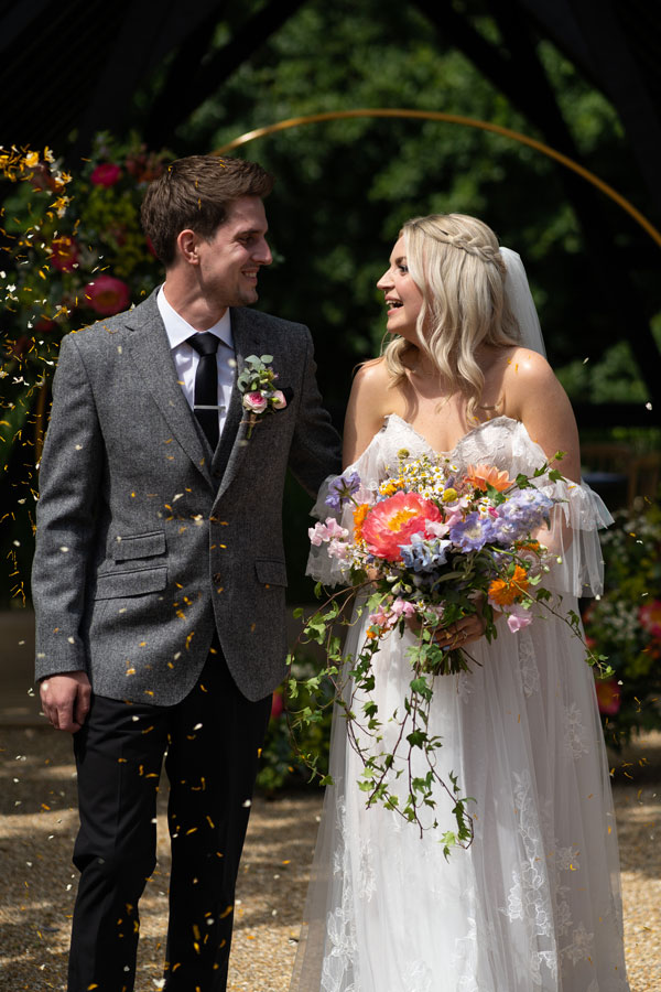 documentary wedding photographer captures the confetti moment as bride and groom walk up the aisle