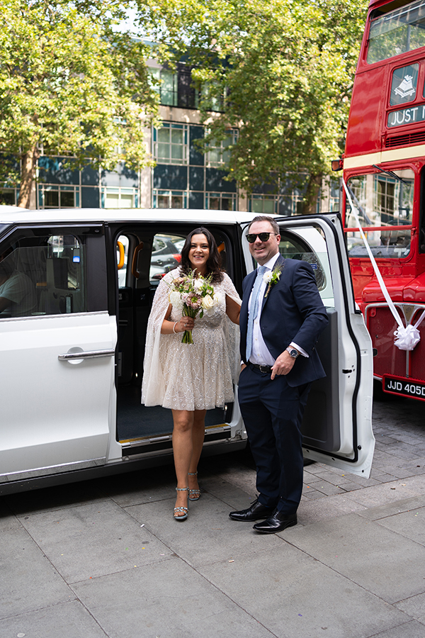 bride and groom exit white taxi on their intimate wedding at the Old Marylebone Town Hall