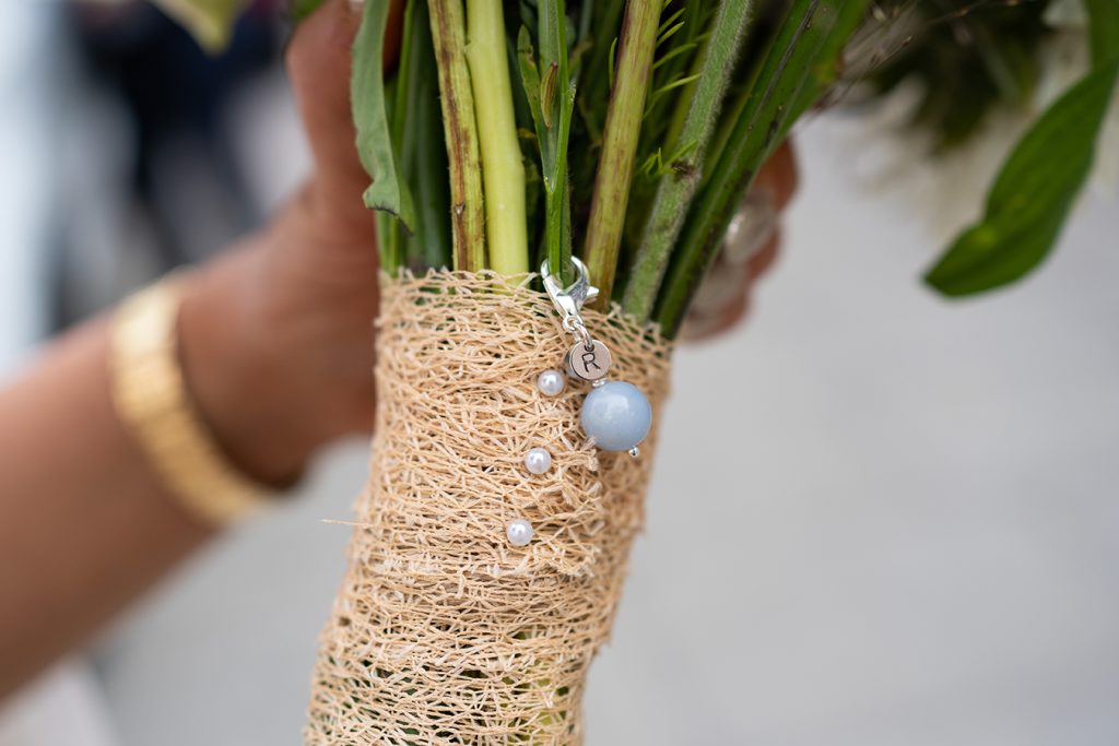 close up of Bride's flowers with R charm for her finance