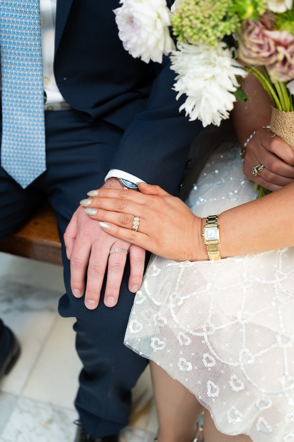close up of bride and grooms hands showcasing their new wedding rings